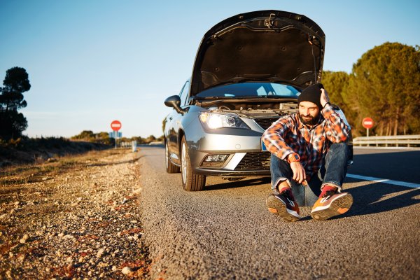 man sitting down on the side of the road car broken extended car warranties